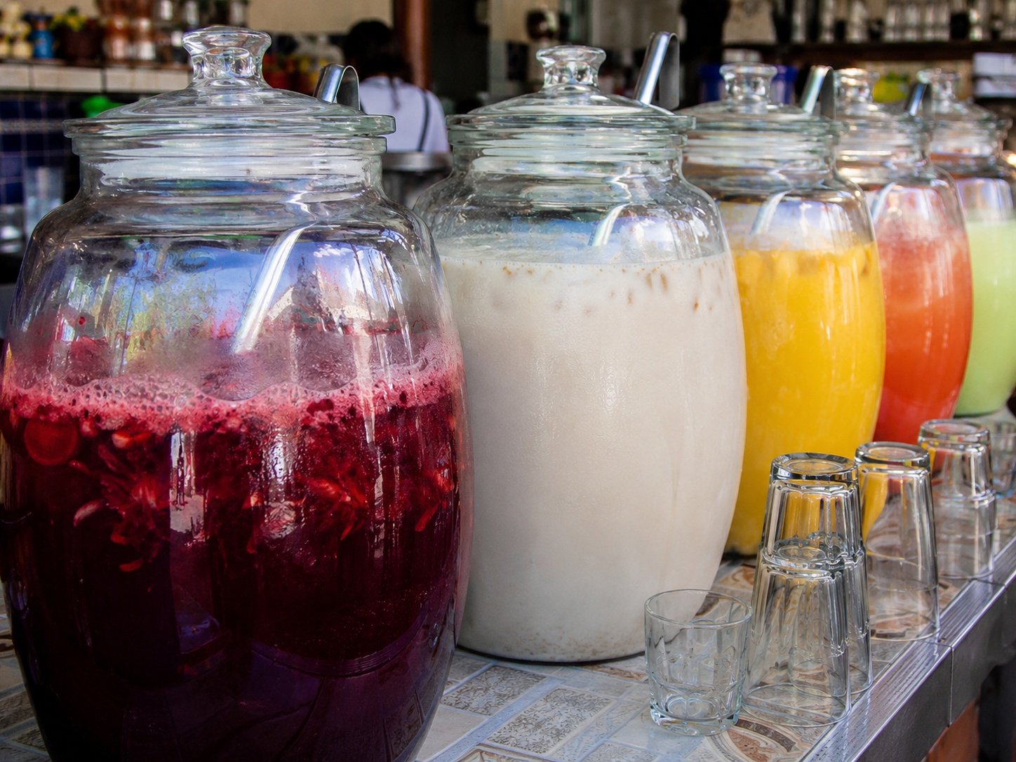 Large vitroleros filled with traditional Mexican aguas frescas