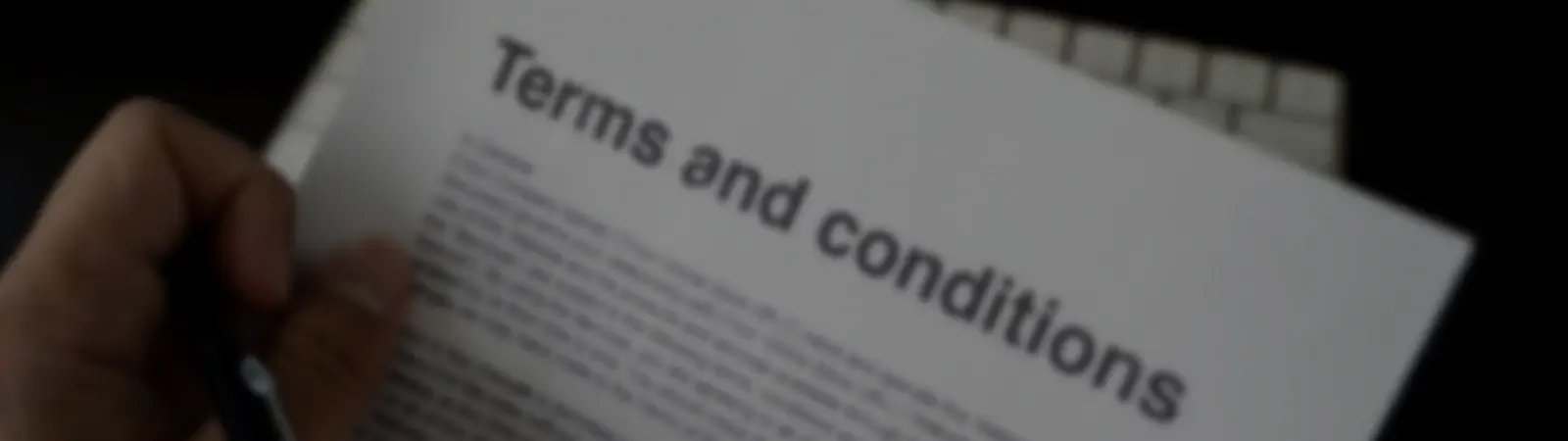 A close-up view of a document titled 'Terms and Conditions,' highlighting the importance of understanding legal agreements and contractual obligations before signing.